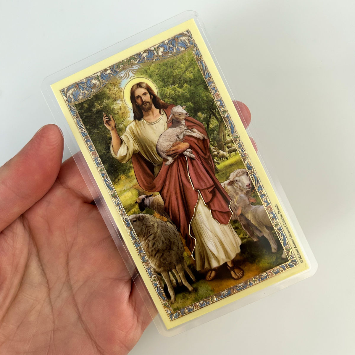 This laminated holy card features a beautiful Catholic image of Jesus the Good Shepherd on the front with a distinctive gold foil stamping design around the edge. It includes "Psalm 23" on the back