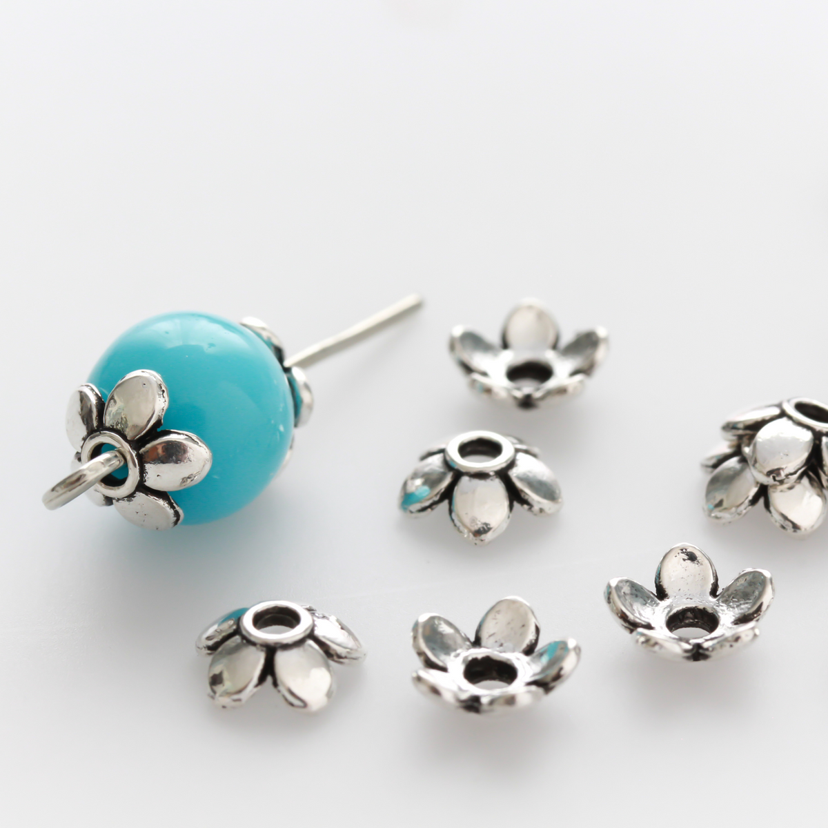 Flower shaped zinc alloy antiqued silver bead caps that are 6mm in diameter