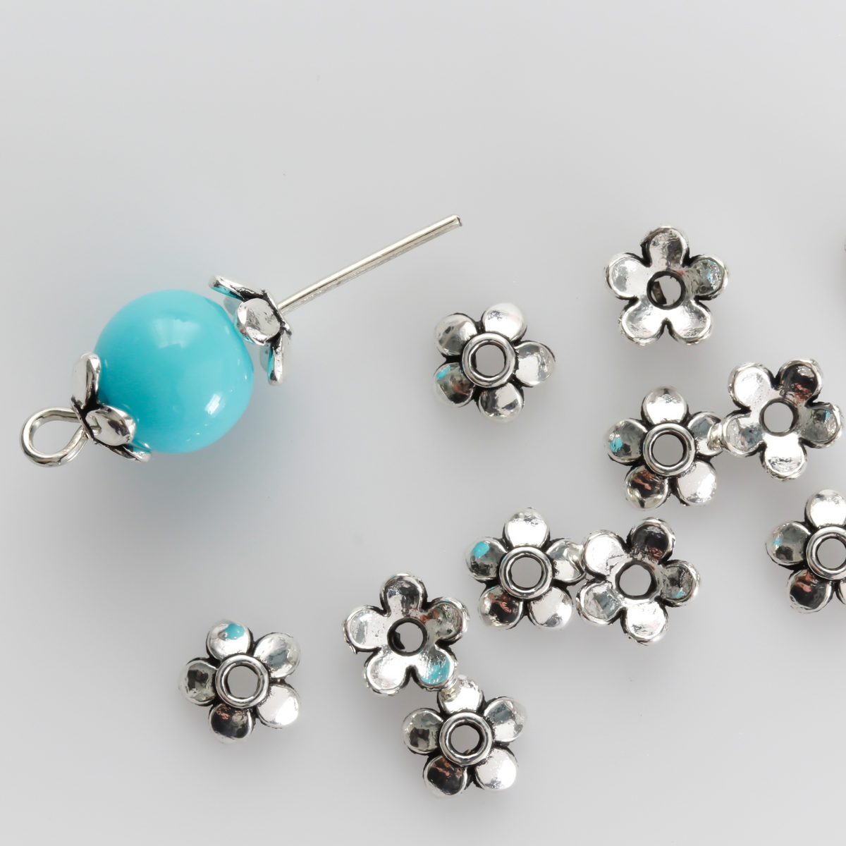 Flower shaped zinc alloy antiqued silver bead caps that are 6mm in diameter