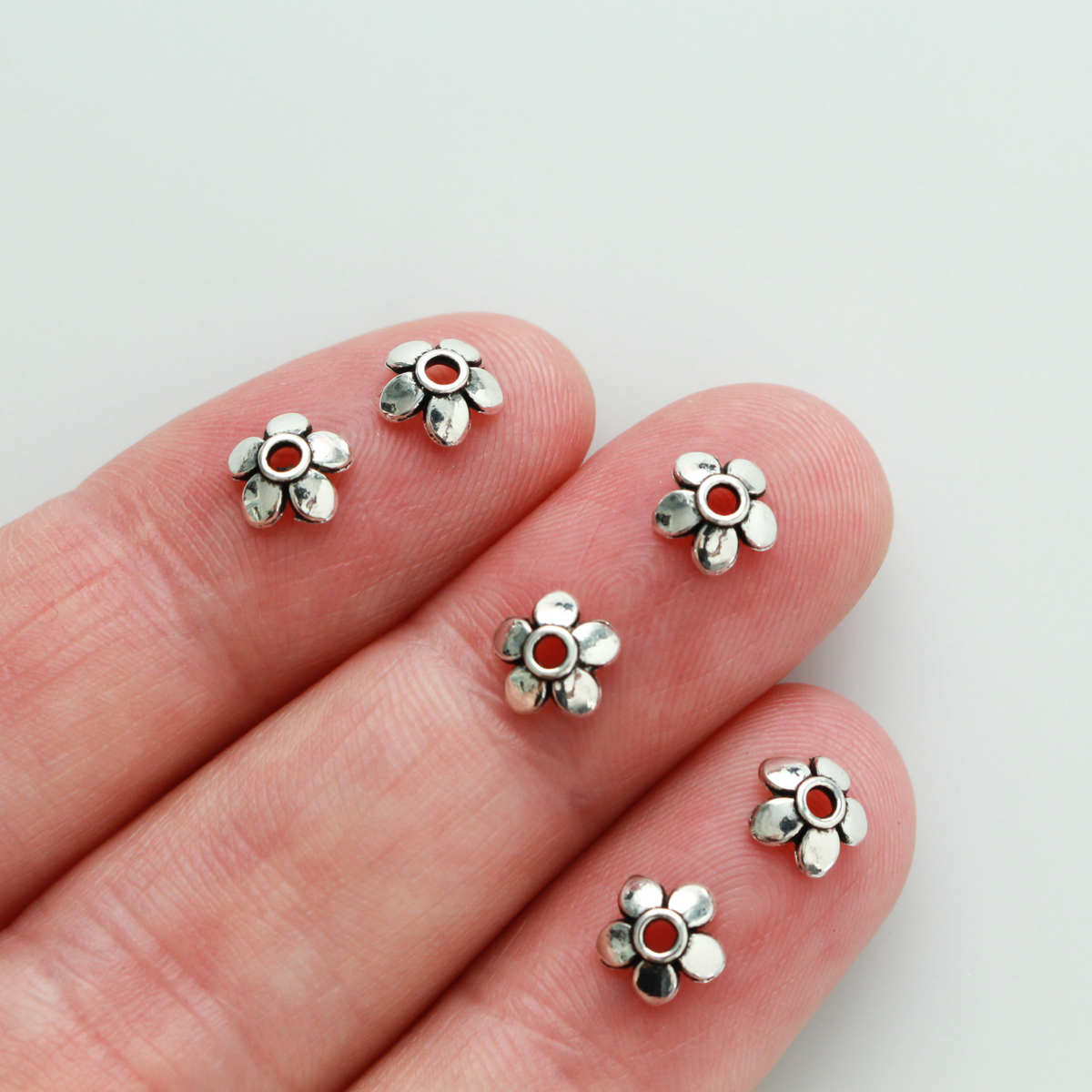 Flower shaped zinc alloy antiqued silver bead caps that are 6mm in diameter