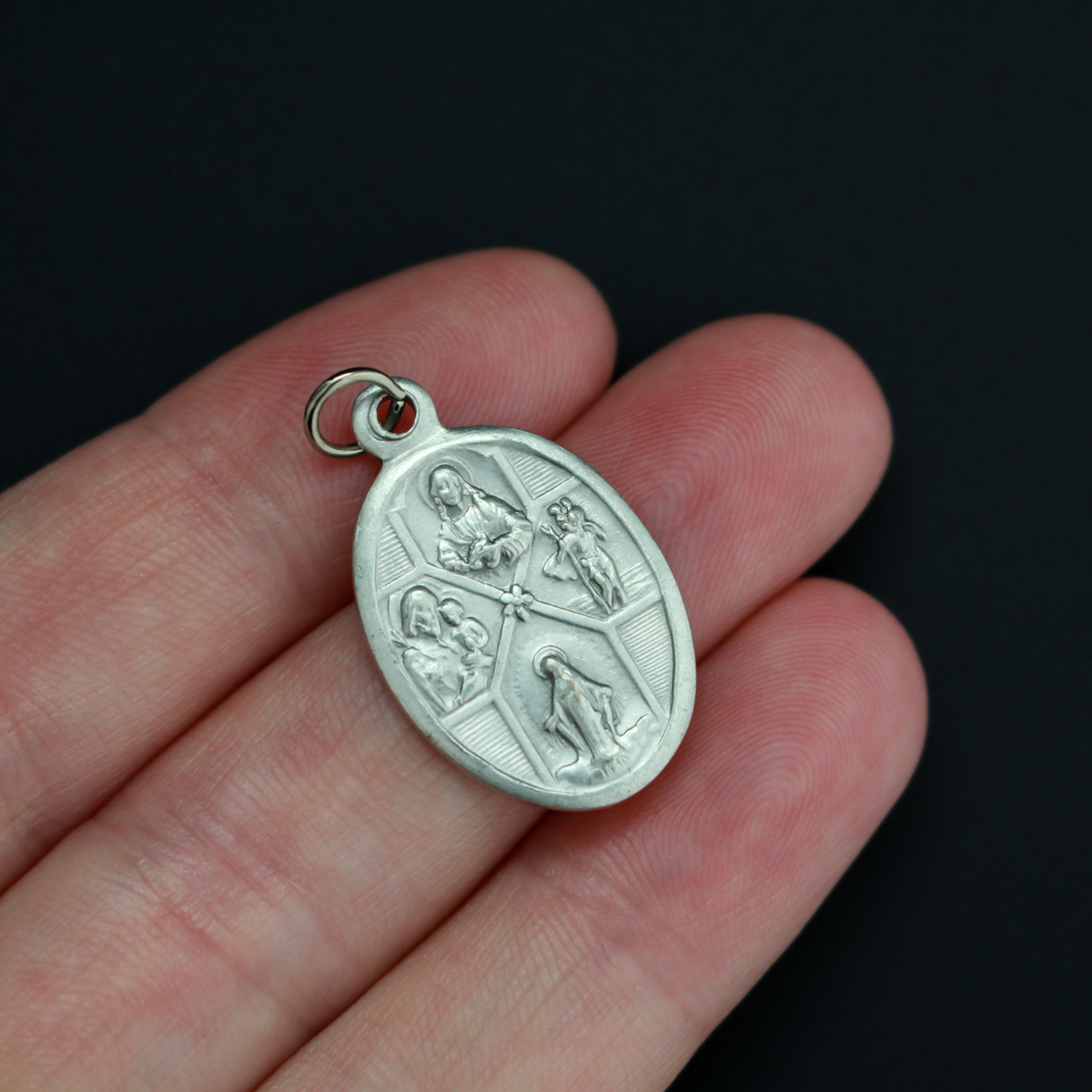Silver oxidized detailed four-way medal that bears the Miraculous Medal, Sacred Heart Scapular Medal, St. Christopher medal, and a St. Joseph medal