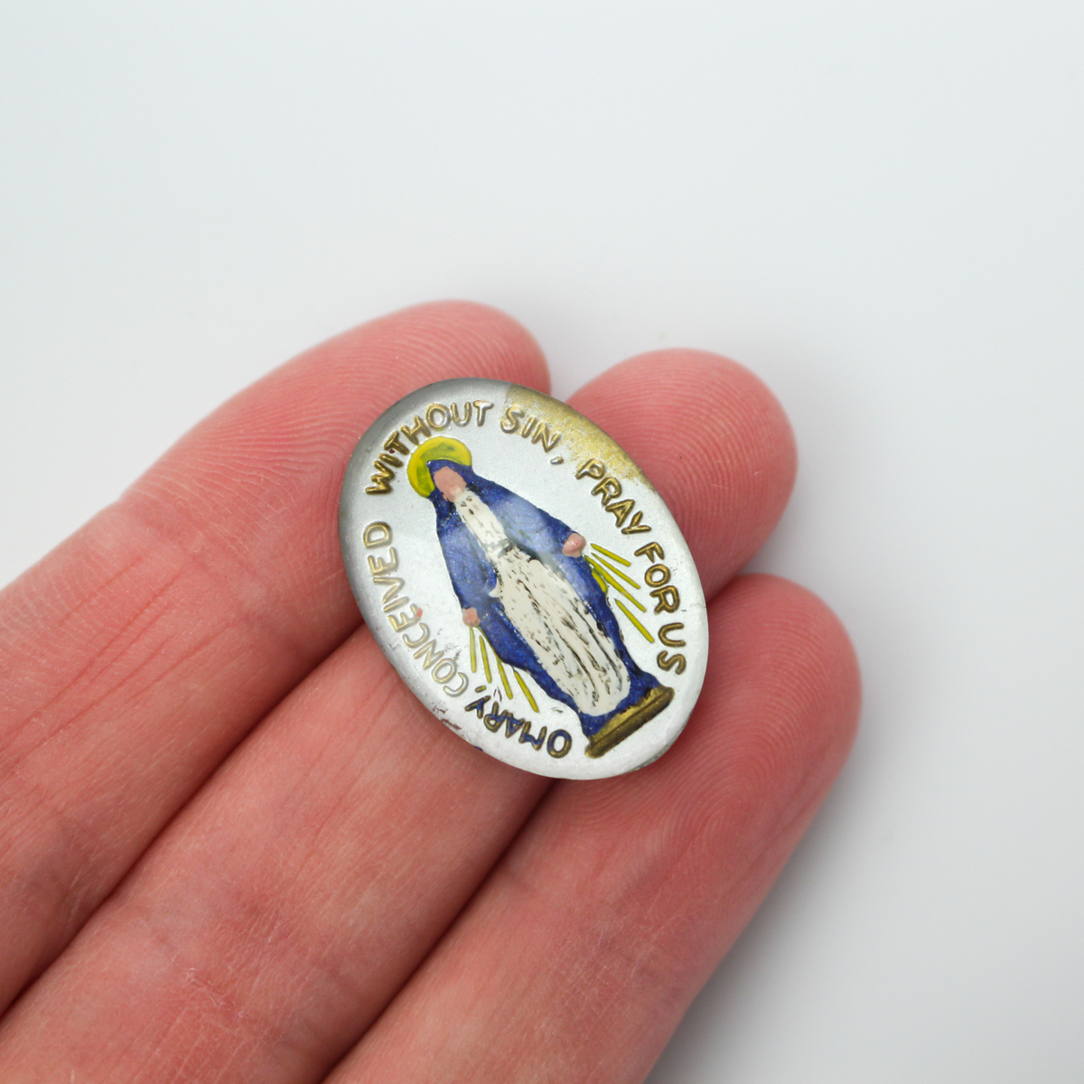 Glass cabochon of the Miraculous medal in a blue and silver design. Hand pressed and painted in the Czech Republi