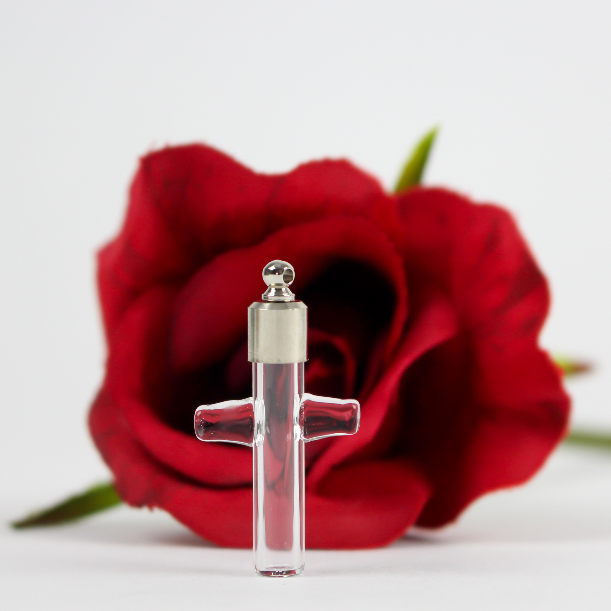Small glass vial shaped like a cross. You can use it to hold a small amount of holy water or ashes of a loved one