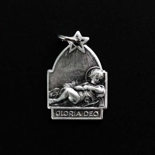 Antique reproduction nativity charm that depicts Jesus in the manger, the bail that holds the jump ring is star-shaped to represent the Star of Bethlehem