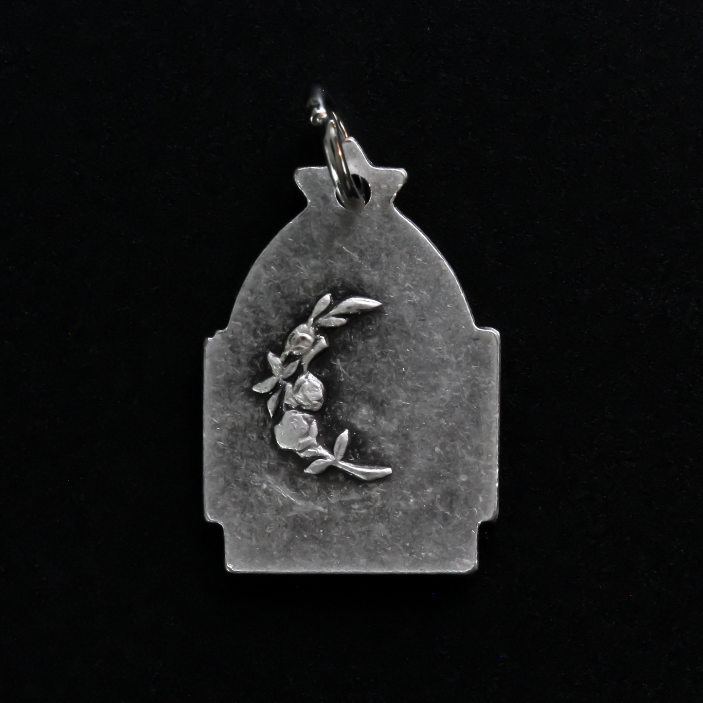 Antique reproduction nativity charm that depicts Jesus in the manger, the bail that holds the jump ring is star-shaped to represent the Star of Bethlehem