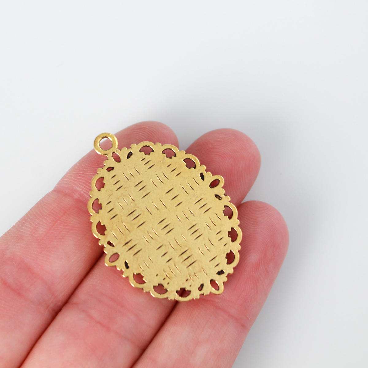 oval pendant cabochon setting in an antiqued gold color. This is an ornate edge bezel cup with a 25mm x 18mm tray.