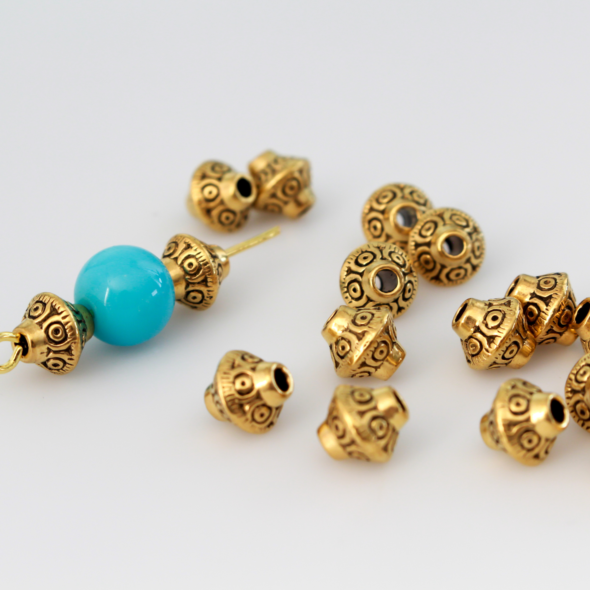 50 metal bicone shaped spacer beads with an antiqued golden finish and a carved dot design