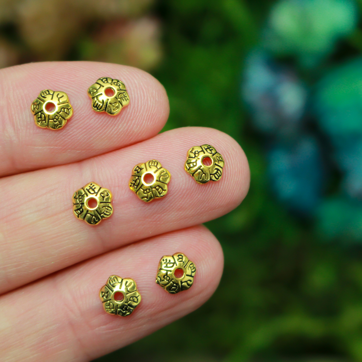 Flower shaped zinc alloy antiqued golden bead caps that are 6mm in diameter. They can fit beads 6mm - 10mm