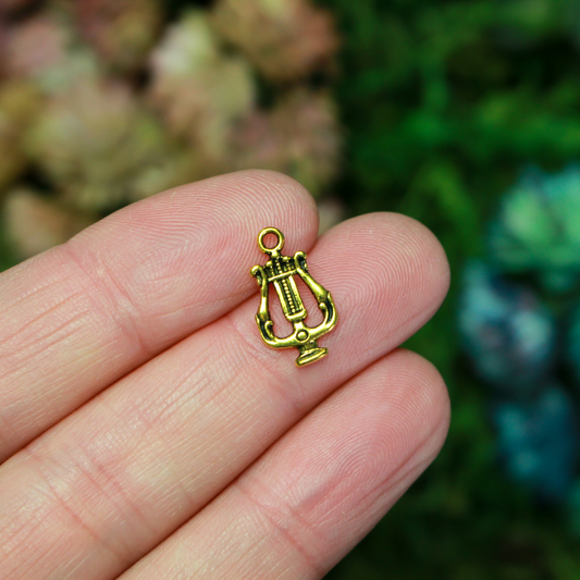 Lyre, or harp charms in an antiqued golden-tone color.