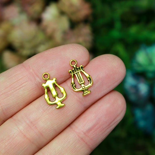 Lyre, or harp charms in an antiqued golden-tone color.