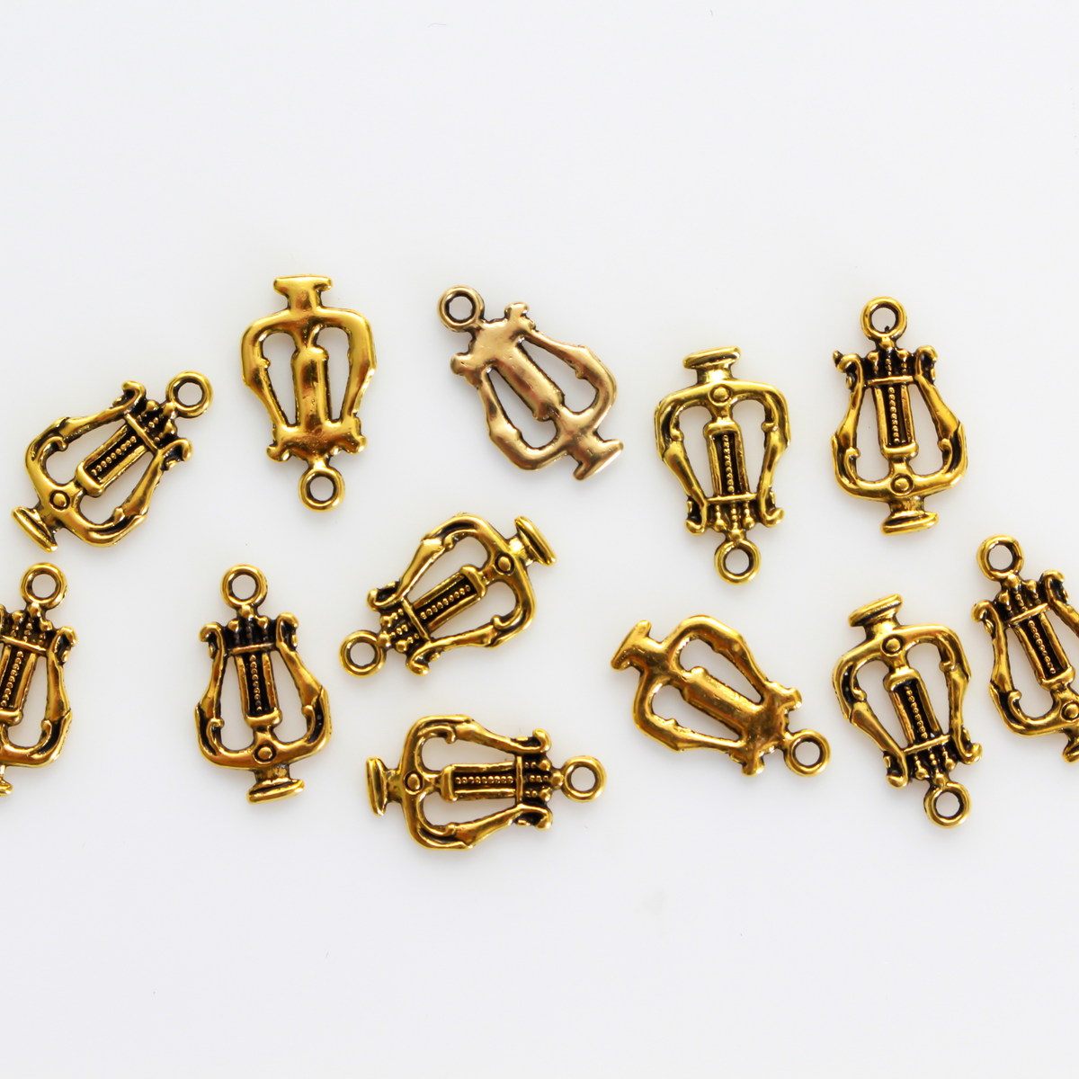 Lyre, or harp charms in an antiqued golden-tone color.