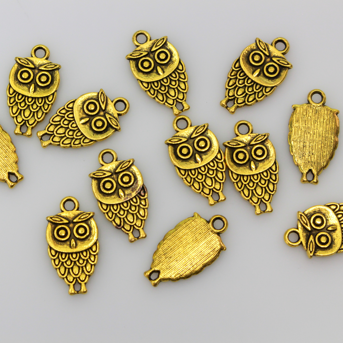 Small owl charm in an antiqued gold tone color, 18mm long