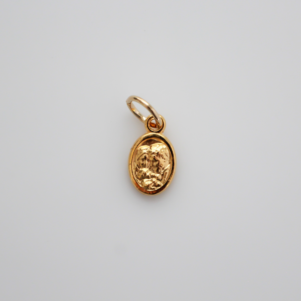 Gold tone mini medal that depicts Saint Joseph holding the child Jesus on one side and the Holy Family depicted on the other side, 1/2" long