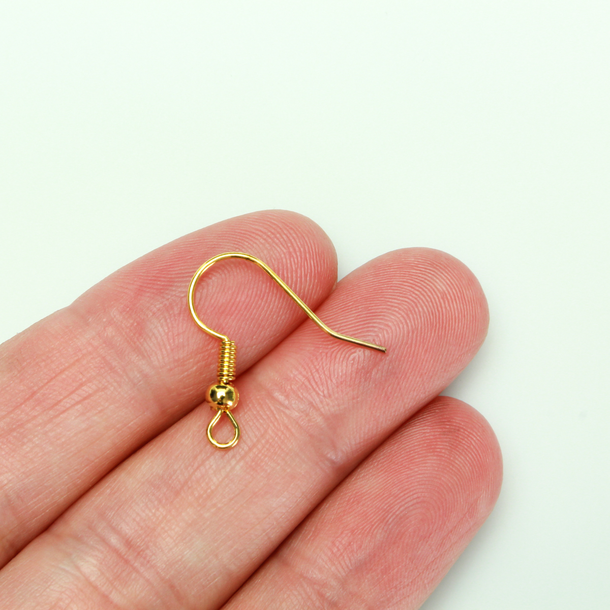 Brass earring hooks with a horizontal loop and a shiny golden finish, 21 gauge wire. Sold in packages of 30 hooks (15 pairs).