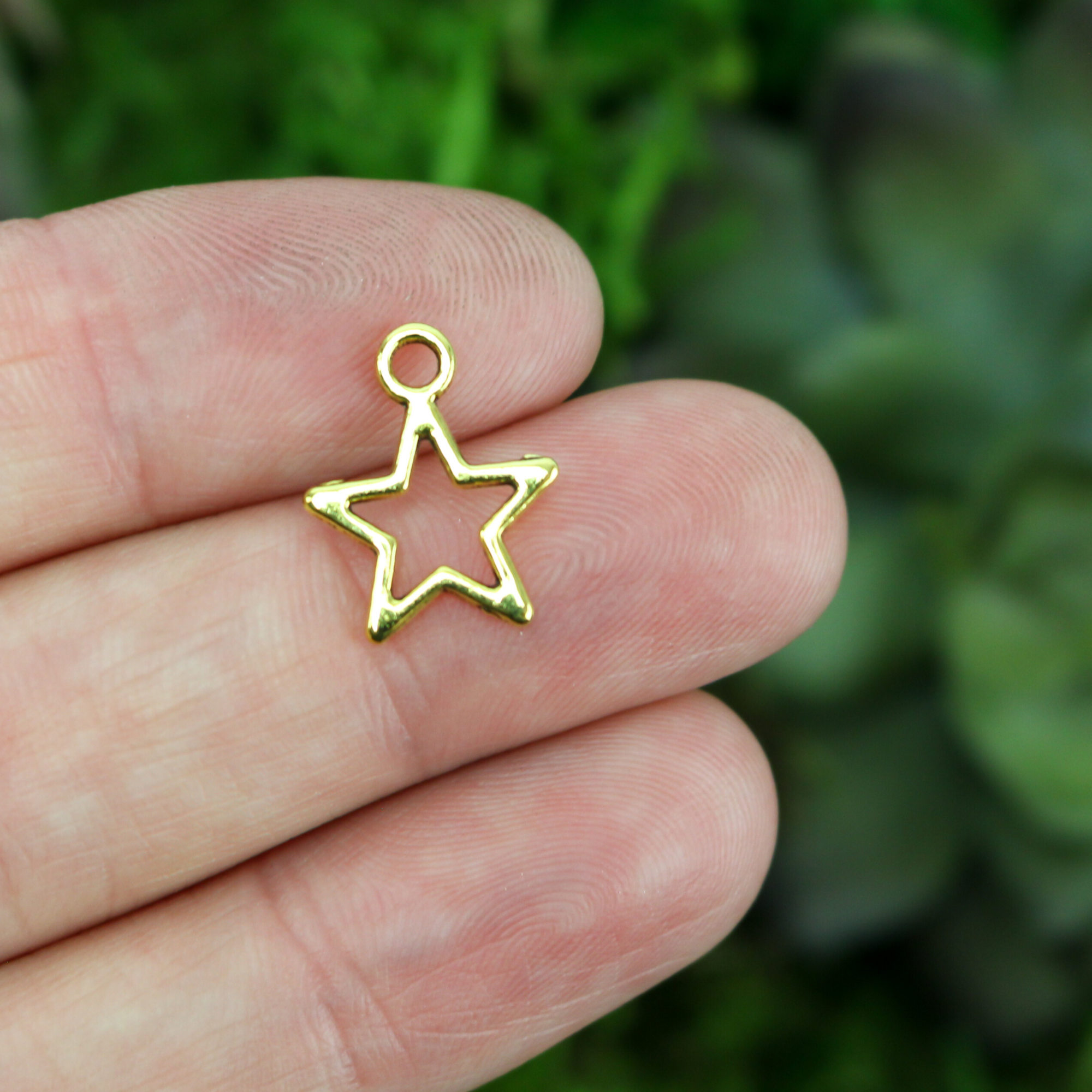 gold-tone small star shaped charm with cutout hollow design