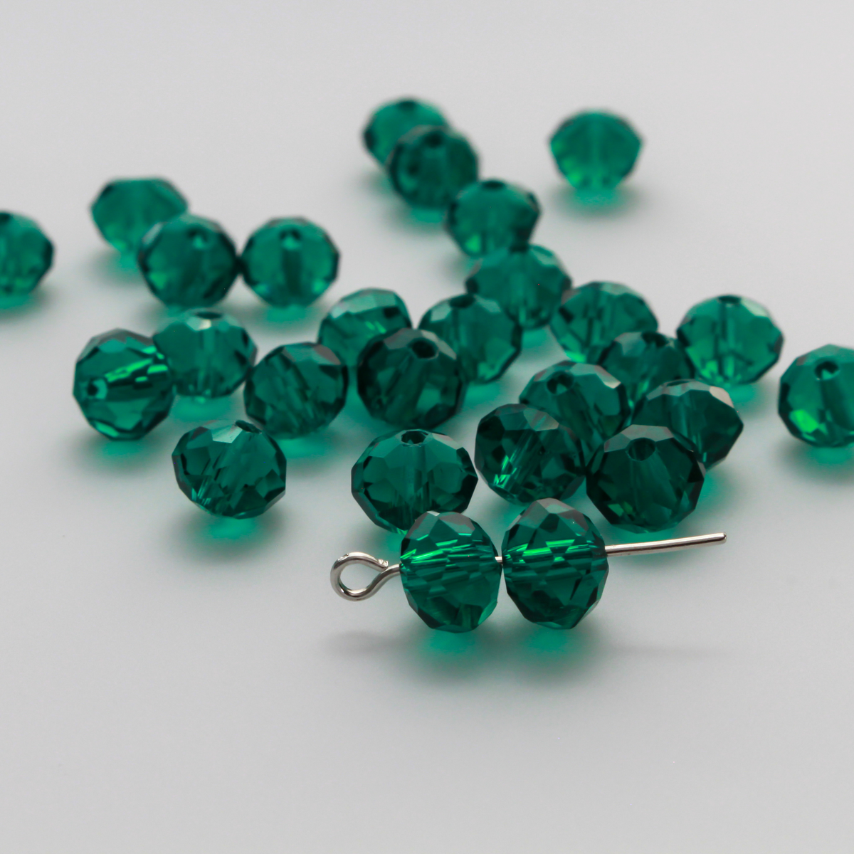 Asian cut crystal glass beads. Peacock Green transparent 8mm x 6.2mm rondelle faceted beads. Sold in packs of 60 beads