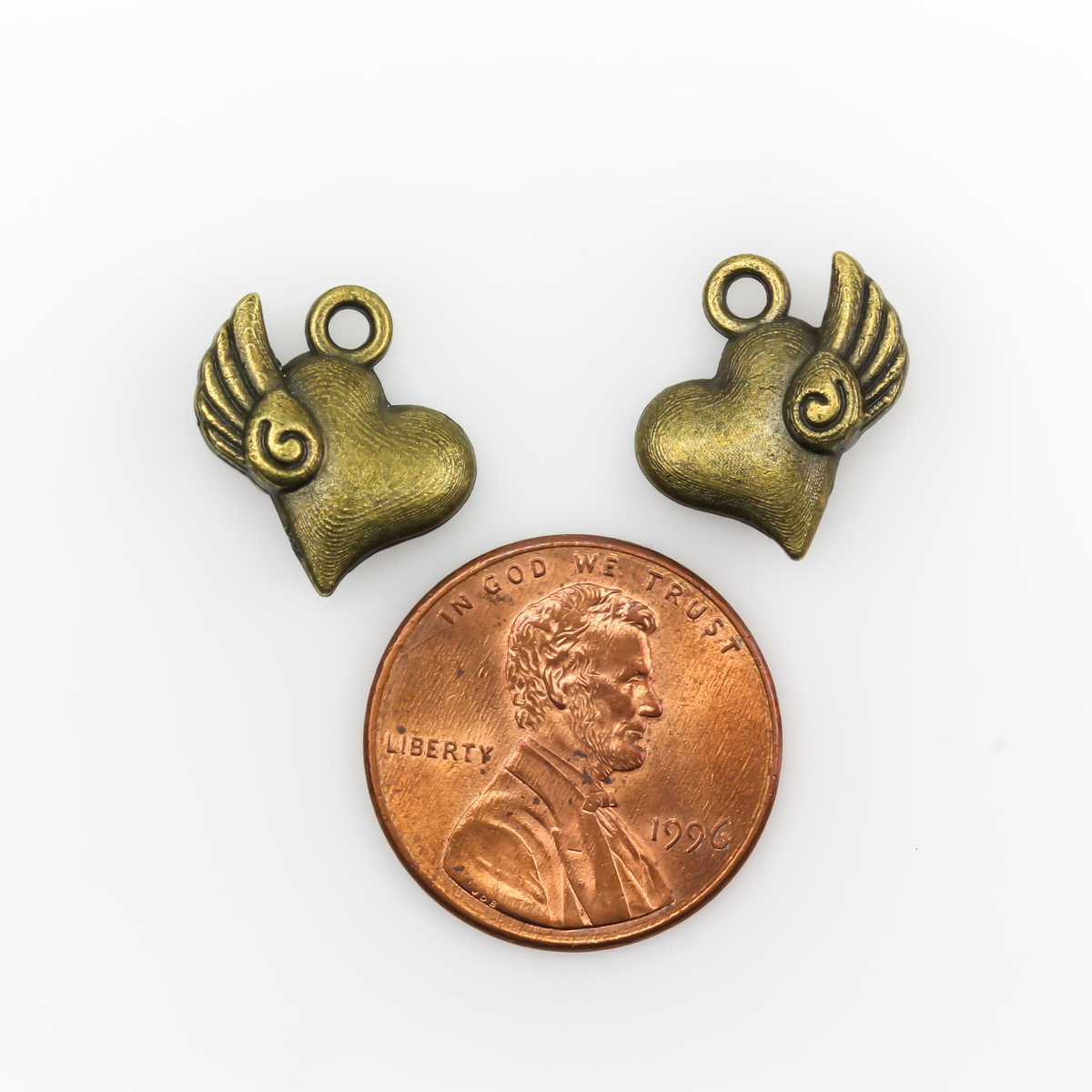 Heart charm with a small wing on the side in antiqued bronze color, 13mm x 13mm
