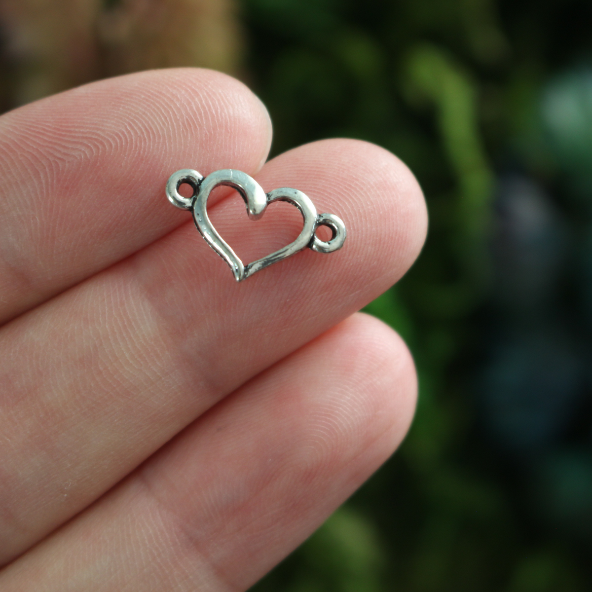 Hollow heart connector links that are sold in packs of 20 pieces.