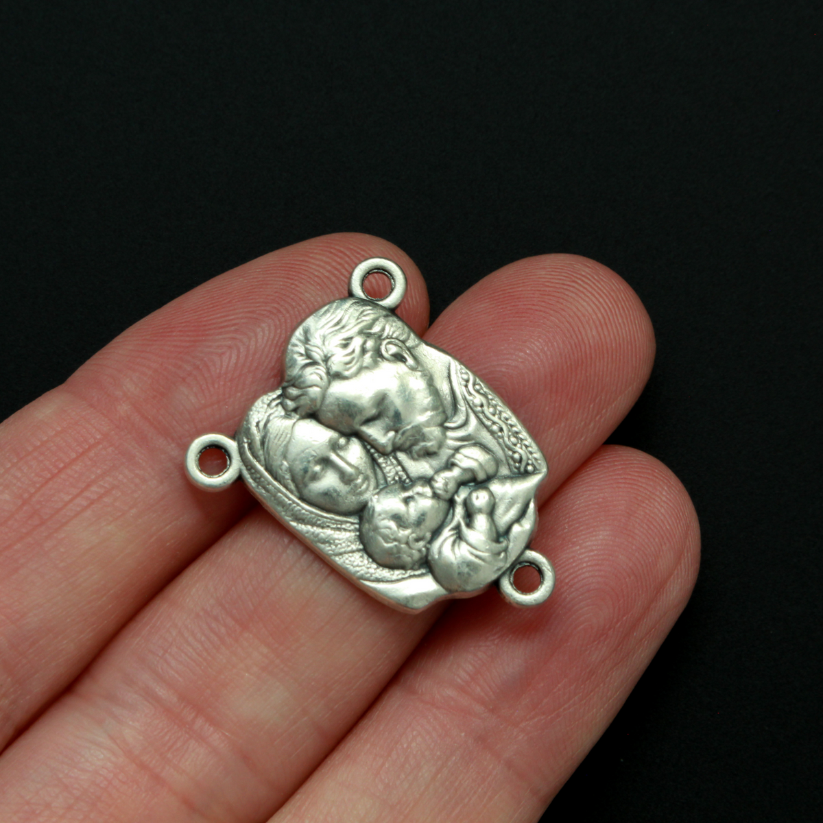 This rosary centerpiece features an image of the Holy Family on the front and "Pray For Us" on the back