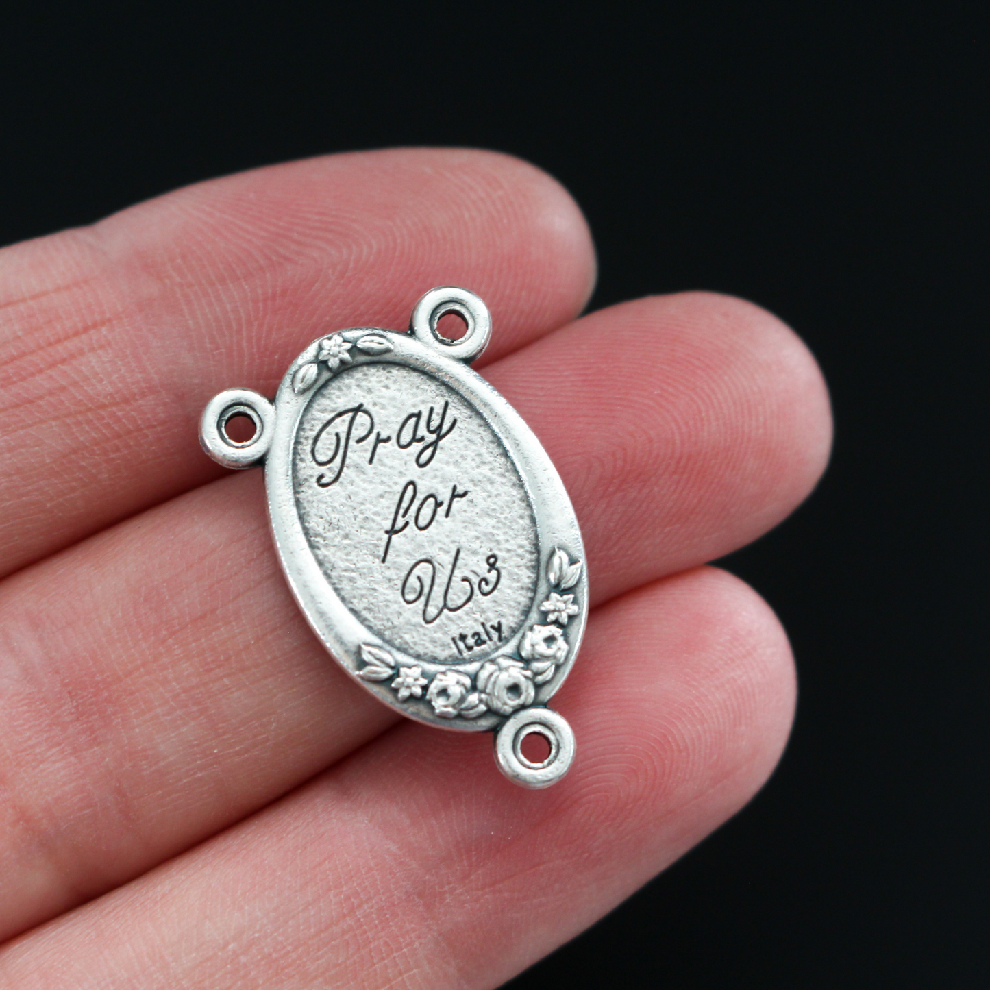 Rosary center that has a full-color image of the Holy Family inlaid in a silver oxidized center with flower details on the edge