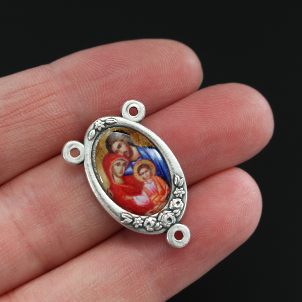 Rosary center that has a full-color image of the Holy Family inlaid in a silver oxidized center with flower details on the edge