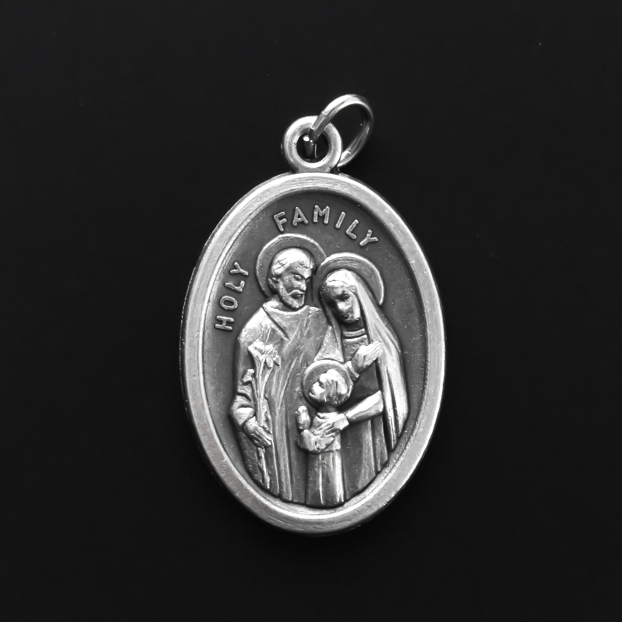 Holy family medal. The front of the medal depicts the child Jesus, Joseph, and Mary. The reverse side of the medal depicts the Holy Spirit.