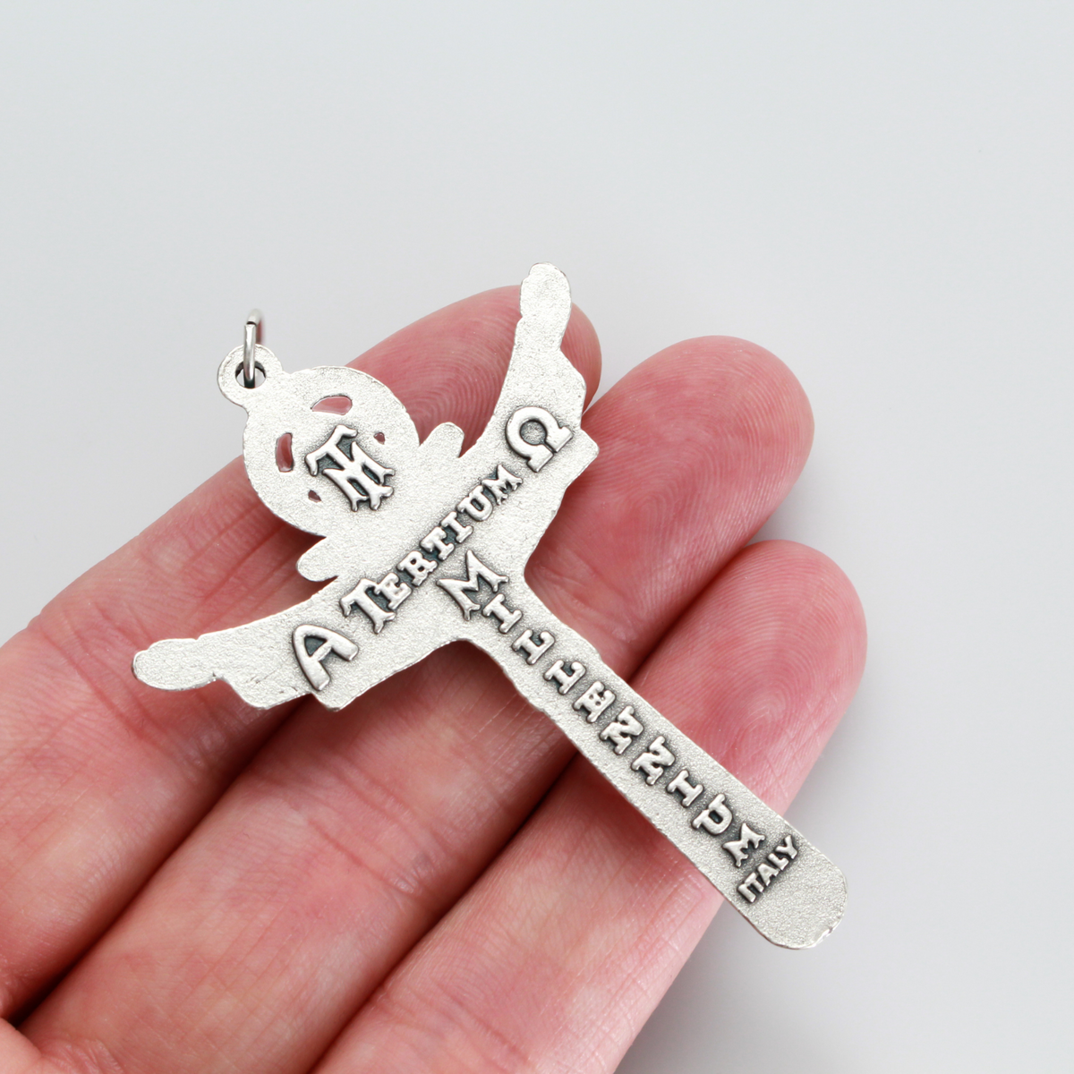 Holy trinity crucifix with the father, the son, and the holy ghost represented on the front of the crucifix. The backside of the cross is marked "Tertium Millennium" with the Greek letters Alpha and Omega