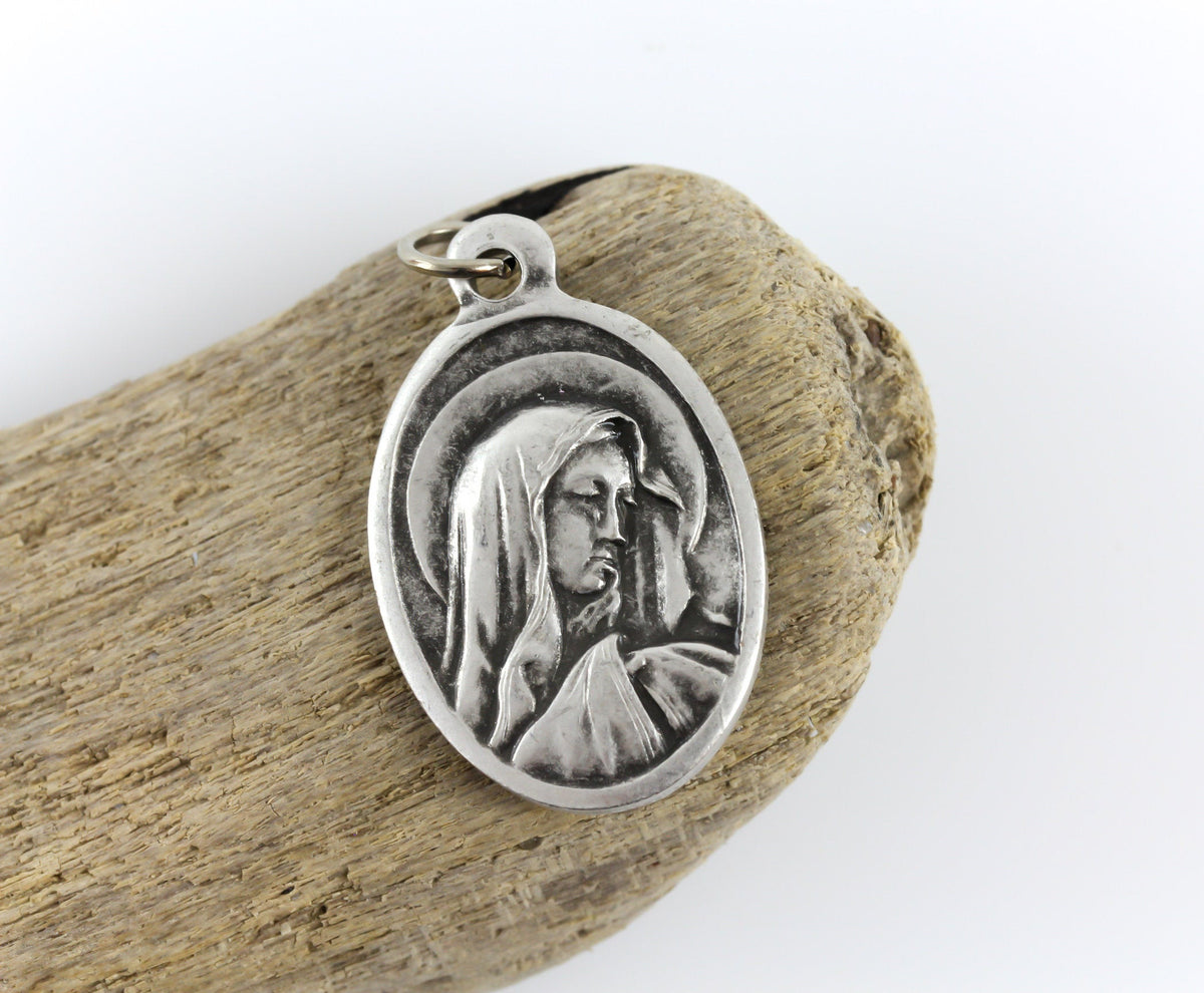 Our Lady of Sorrows die cast silver oval one inch medal