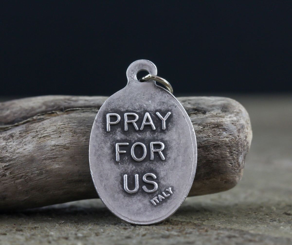 die cast silver medal inscribed with pray for us