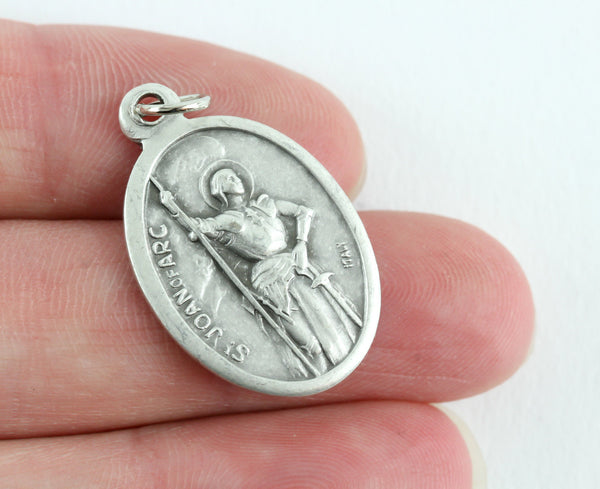womans hand holding die cast patron saint medal