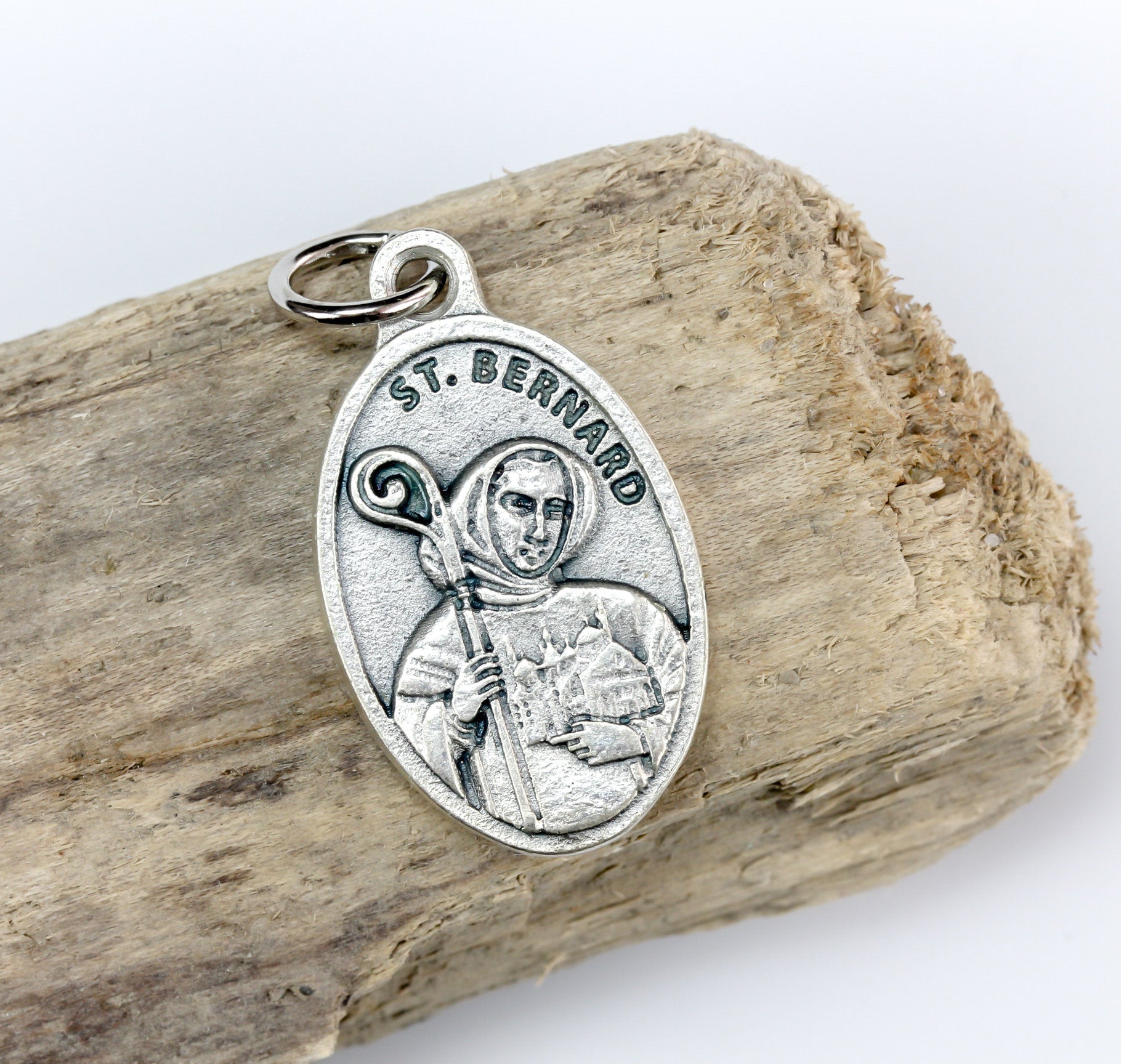 Saint Bernard of Clairvaux medal that depicts the saint on the front holding a church and crozier. Marked "Pray For Us" on the back