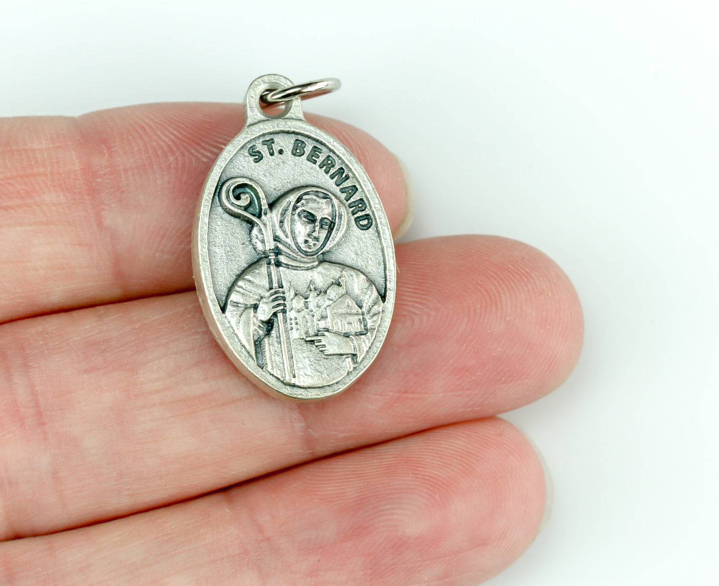 Saint Bernard of Clairvaux medal that depicts the saint on the front holding a church and crozier. Marked "Pray For Us" on the back