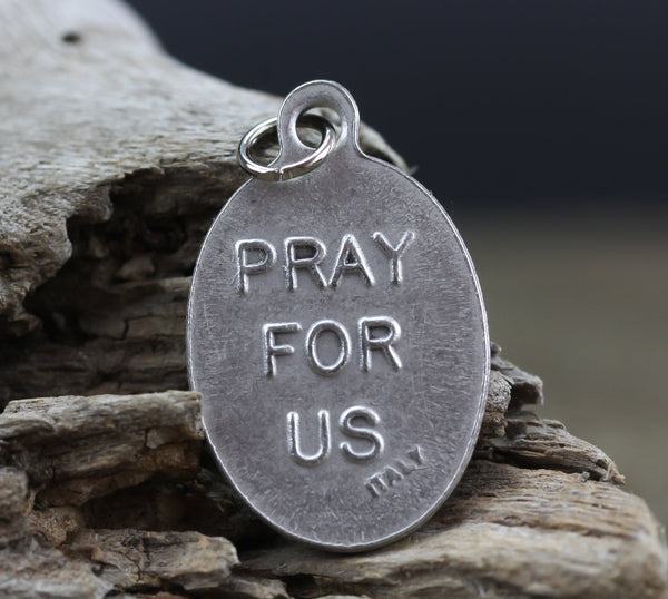 die cast silver medal inscribed with pray for us