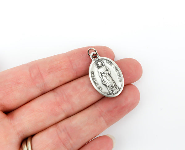 womans hand holding catholic patron saint joseph medal