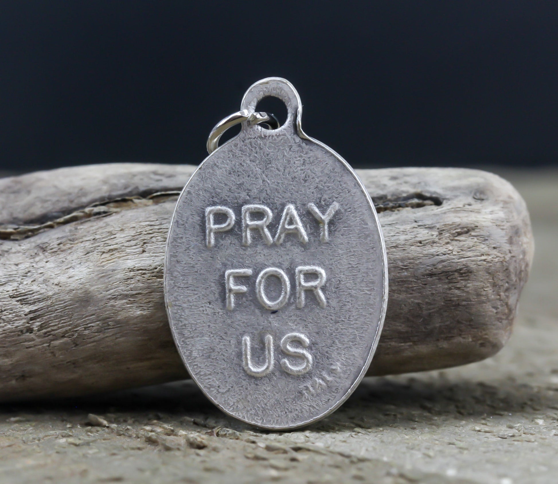 die cast silver medal inscribed with pray for us