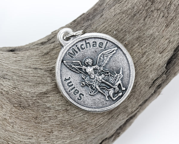 die cast silver medal depicting archangel michael slaying dragon