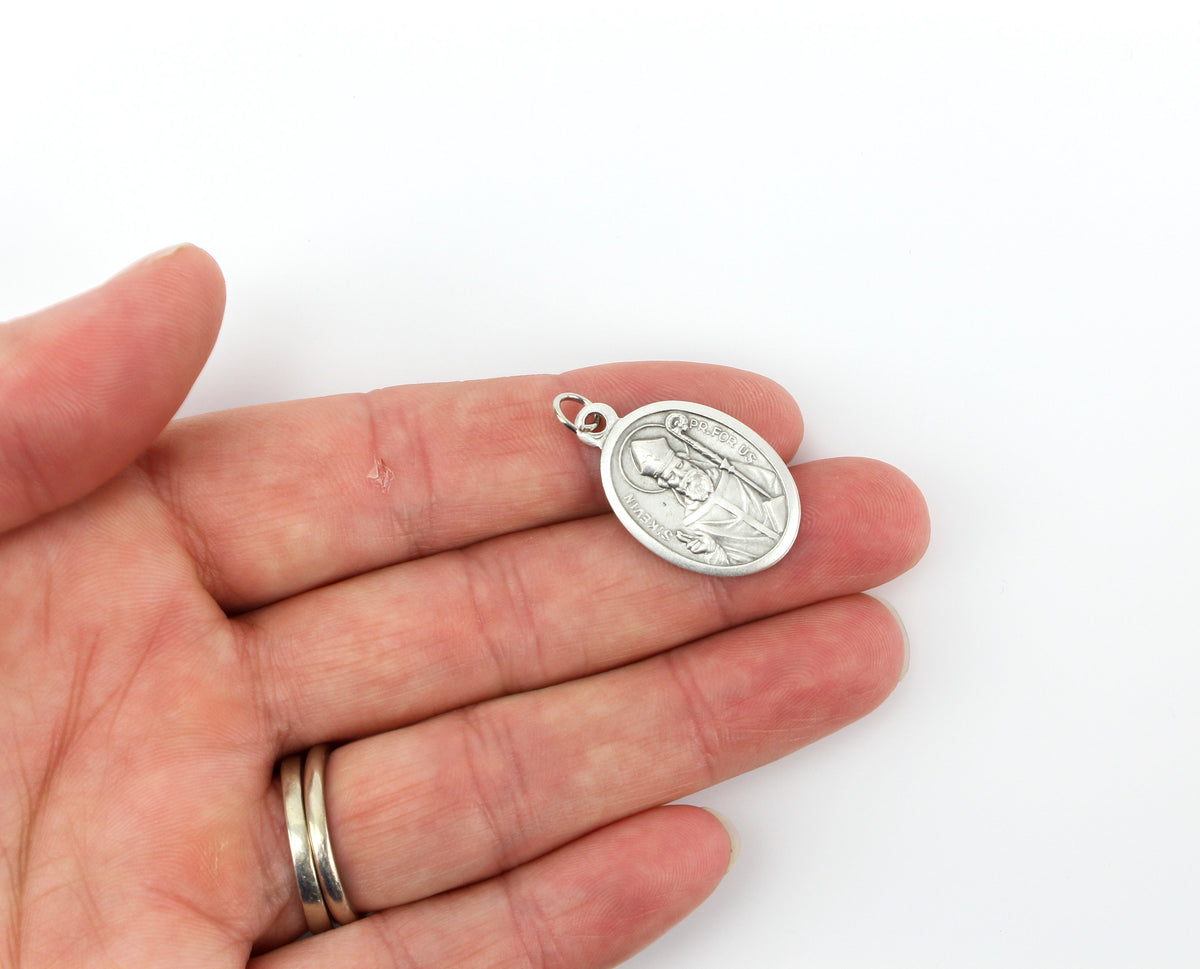 womans hand holding catholic patron saint kevin medal