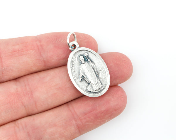 womans hand holding catholic patron saint patrick  medal