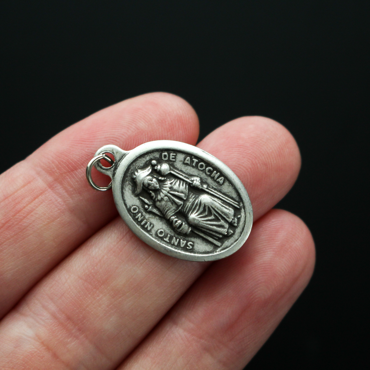 Santo Nino de Atocha medal that is marked "Pray For Us" on the reverse side