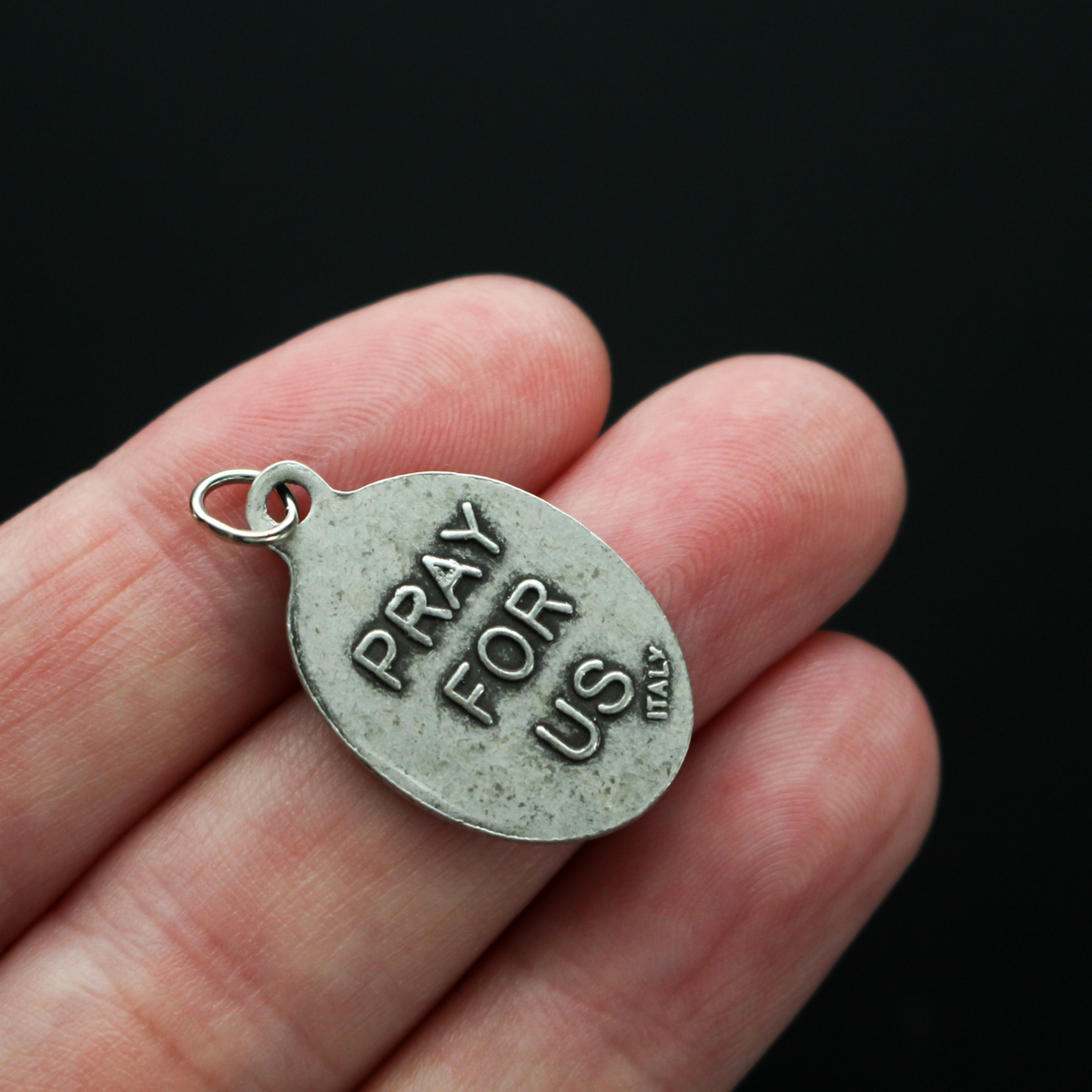 Santo Nino de Atocha medal that is marked "Pray For Us" on the reverse side