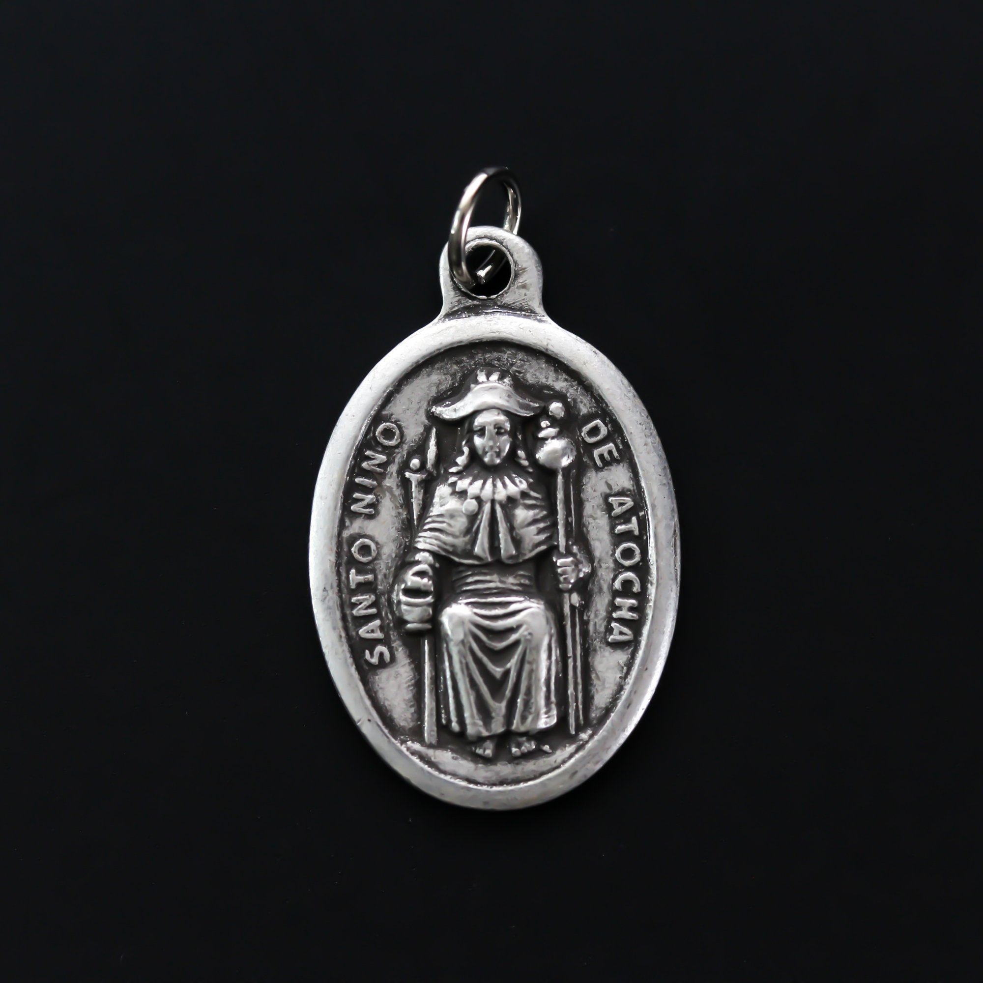 Santo Nino de Atocha medal that is marked "Pray For Us" on the reverse side