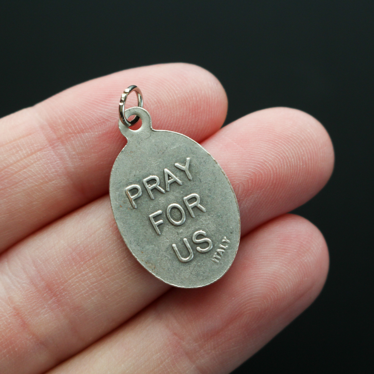 Infant Jesus of Prague medal that depicts the Infant Jesus on the front and is marked "Pray For Us" on the back