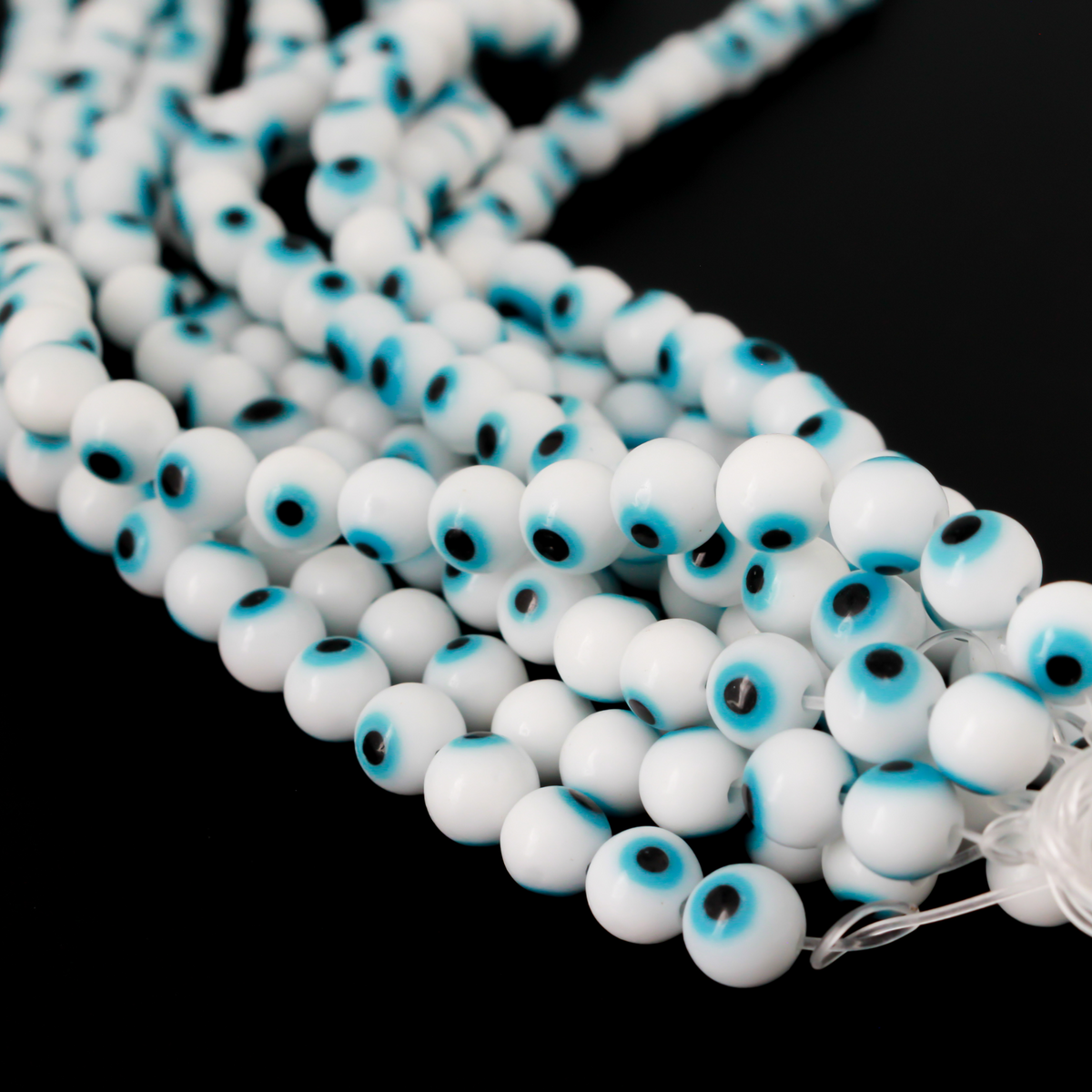Handmade lampwork glass beads featuring the all seeing evil eye. The beads are white with a light sky blue iris and black pupil, 6mm round