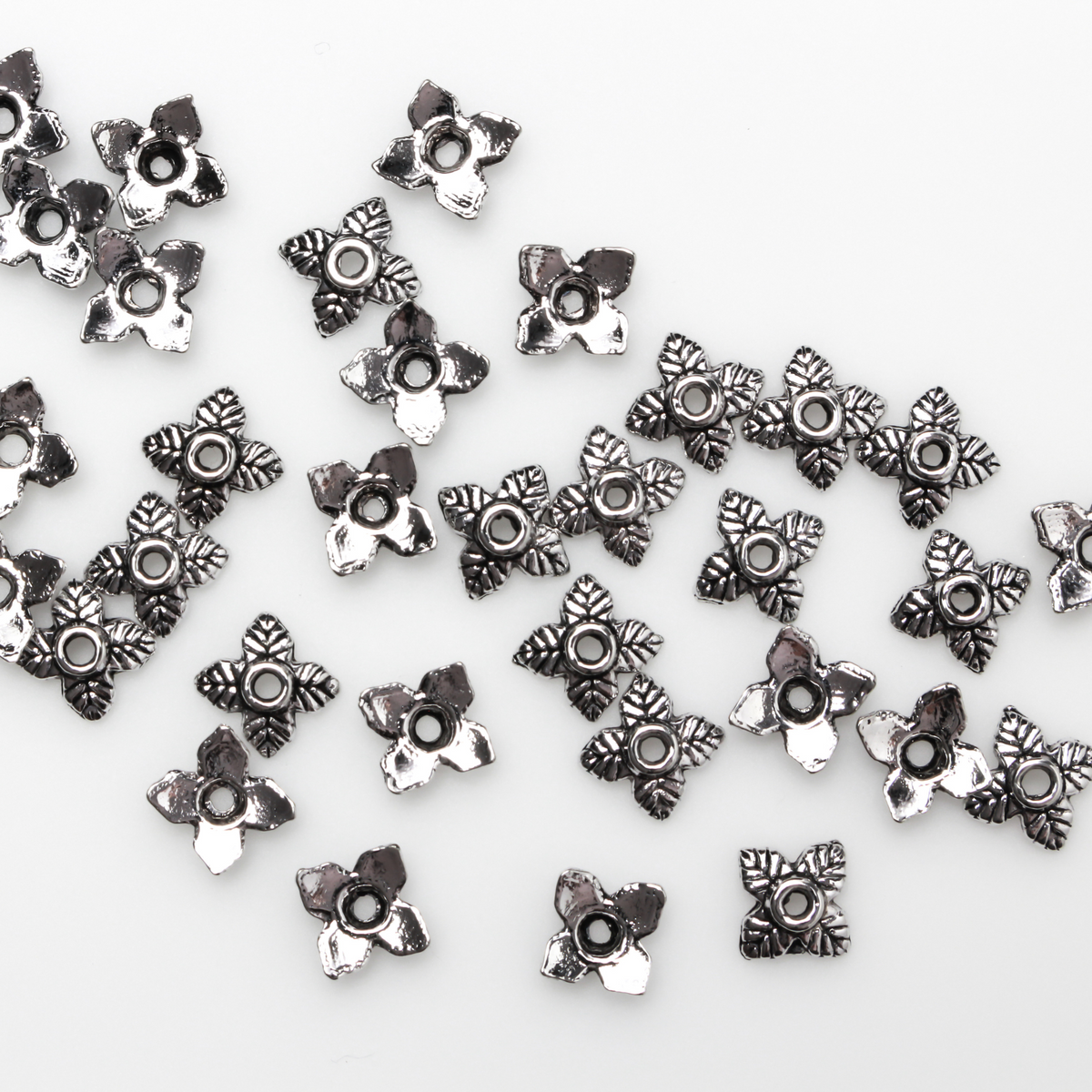 Leaf shaped bead caps with a four leaf pattern. They are 6mm with a 1mm hole