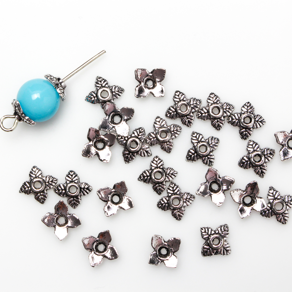 Leaf shaped bead caps with a four leaf pattern. They are 6mm with a 1mm hole
