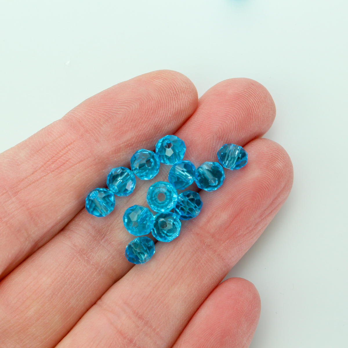Asian cut crystal glass beads. 6mm x 4mm faceted light blue transparent. Sold in packages of 60 beads