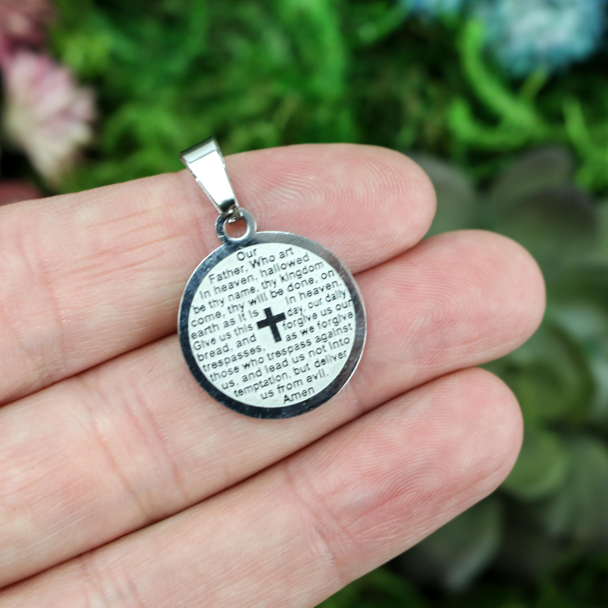 stainless steel round medallion inscribed with the lords prayer