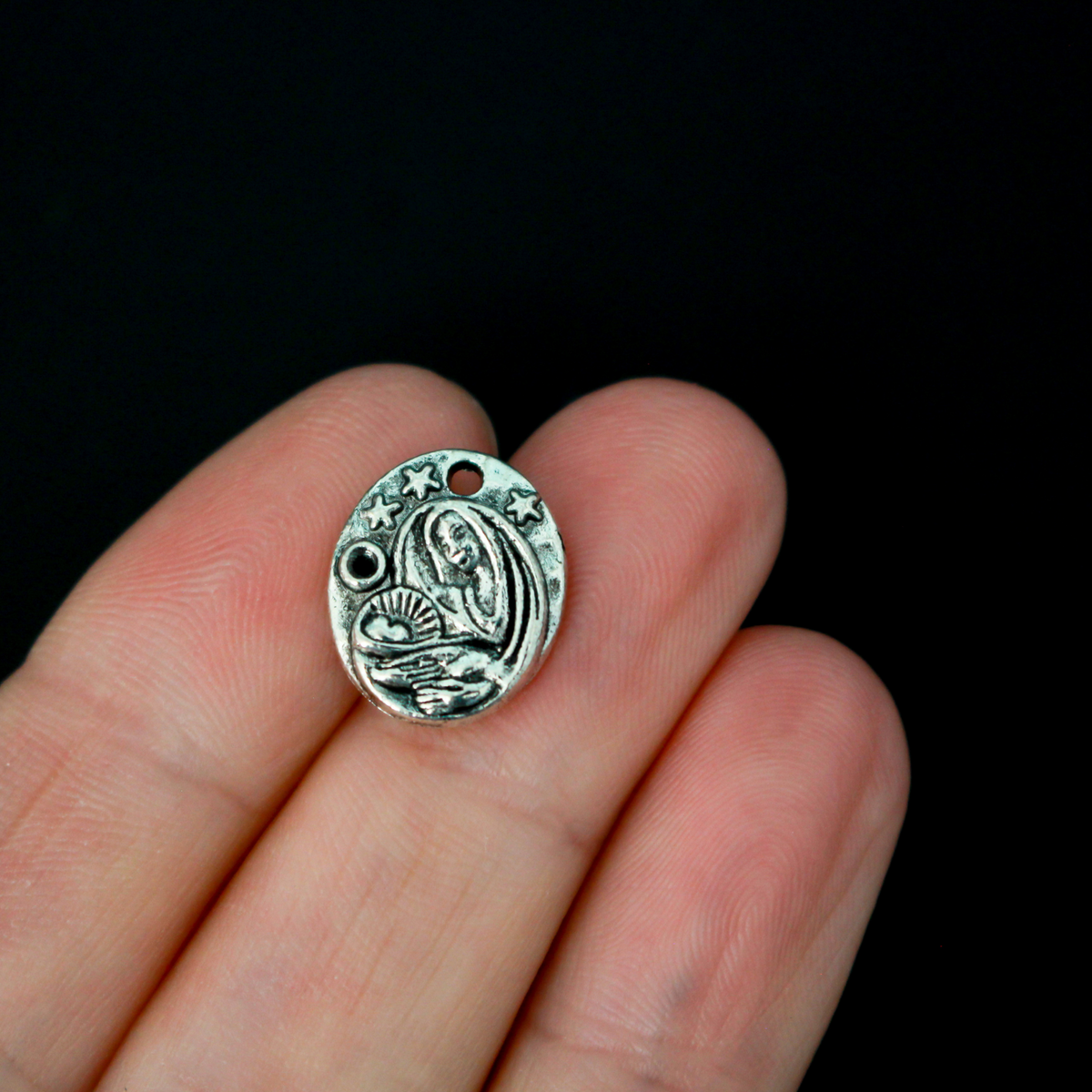This dainty Madonna and child charm is crafted from quality metal and features a detailed design of the Virgin Mary holding infant Jesus