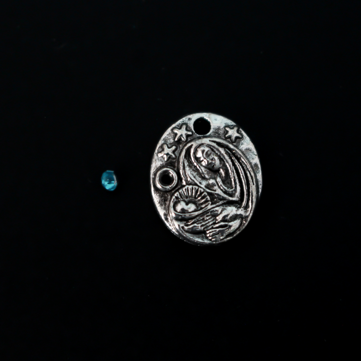 This dainty Madonna and child charm is crafted from quality metal and features a detailed design of the Virgin Mary holding infant Jesus