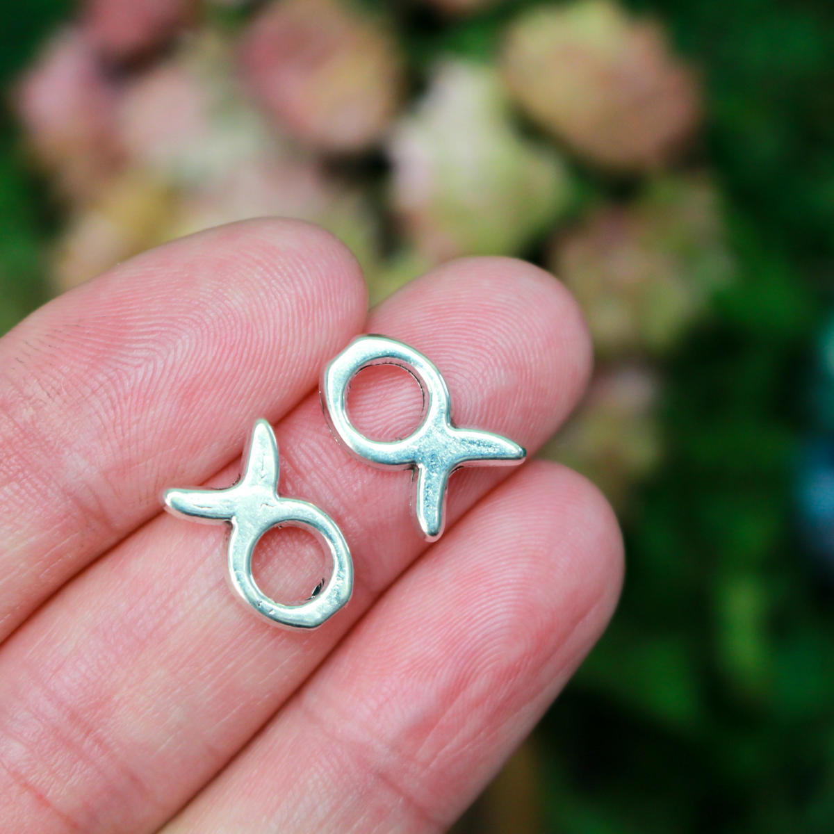 Silver tone bead frames that are shaped like a fish. They fit beads 4mm or smaller 
